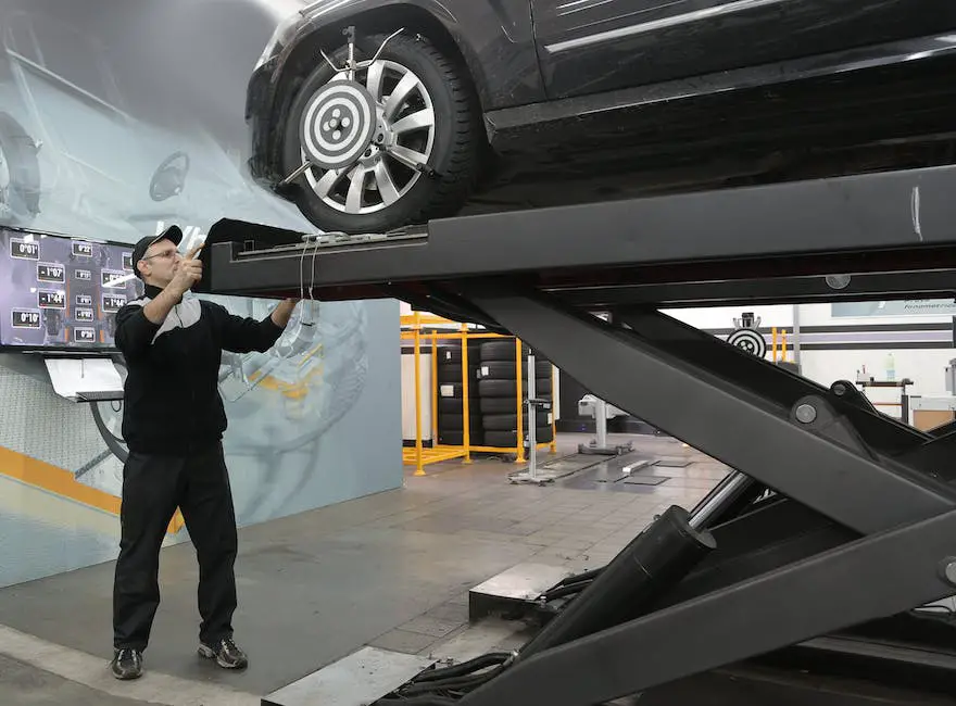 A car with its hood open and a mechanic is checking its transmission fluids