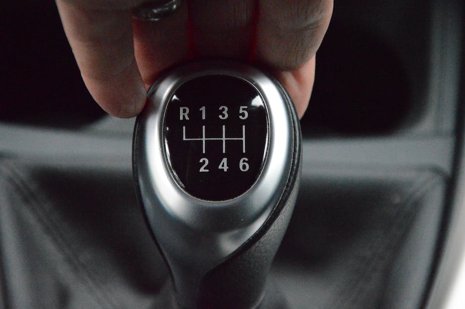 An image of a person holding a car manual while sitting in the car cabin.