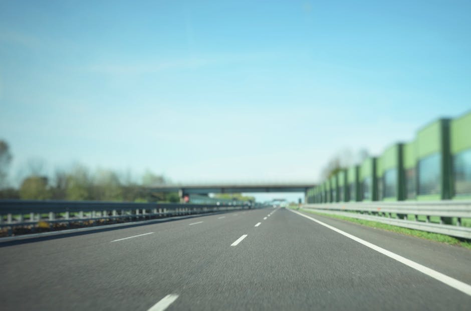 A luxurious SUV on a highway, with green trees in the background.